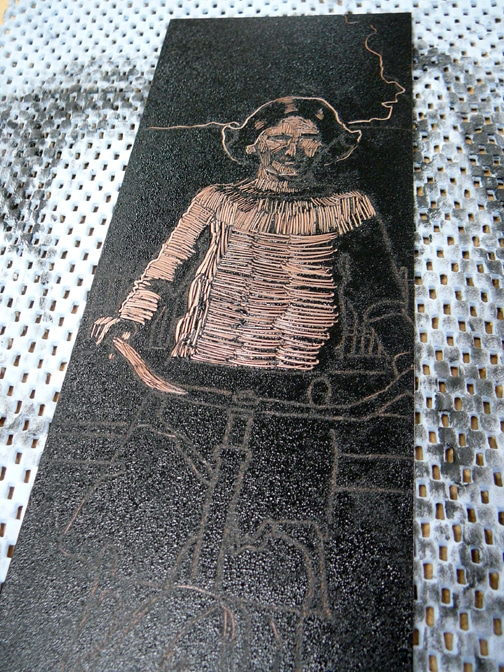 making marks in the wet ink on a copper plate to create a monotype portrait
