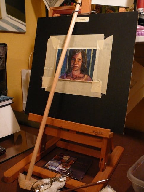 a desktop easel with a mahl stick and the beginnings of a small watercolor portrait