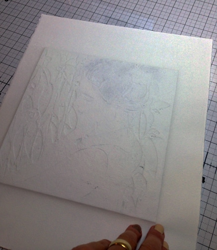 printmaking paper pressed against an inked plate on a press, leaving embossed shapes on the verso of the paper