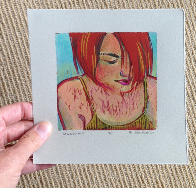 small portrait woodcut printed in two colors and painted with watercolor and colored pencil