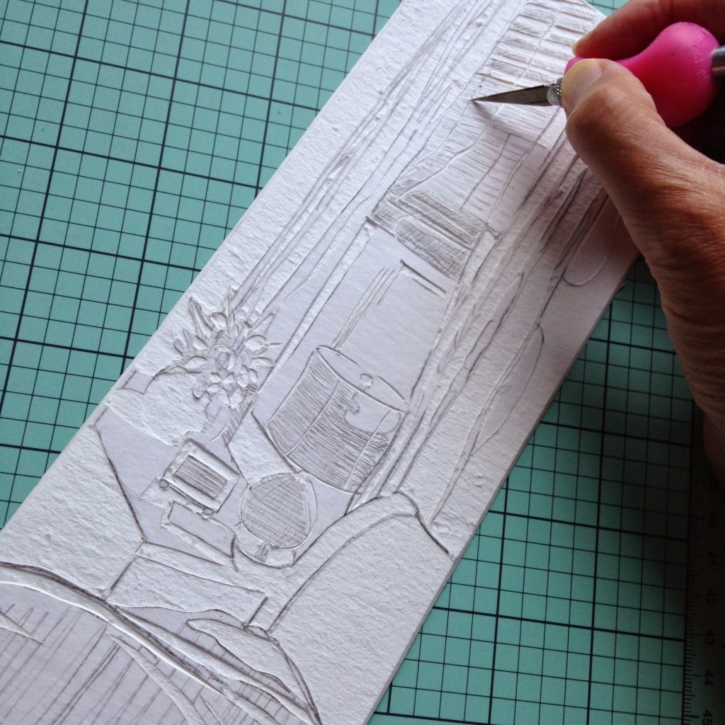 carving shallow grooves from mat board to hold printmaking ink for a collagraph print