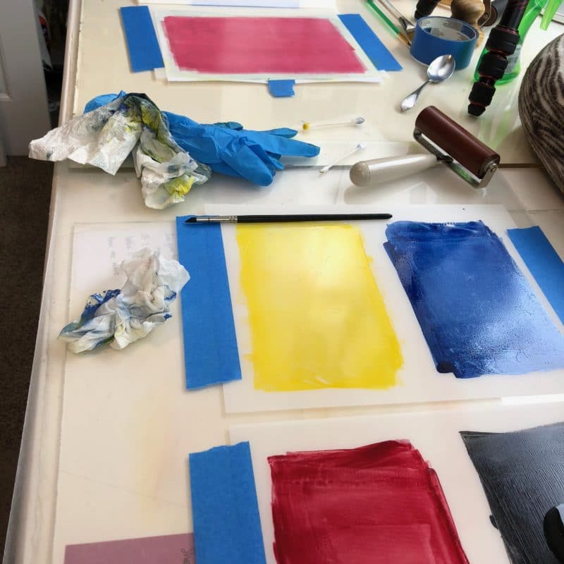 monotype printing set up with four colors of inks on mylar sheets