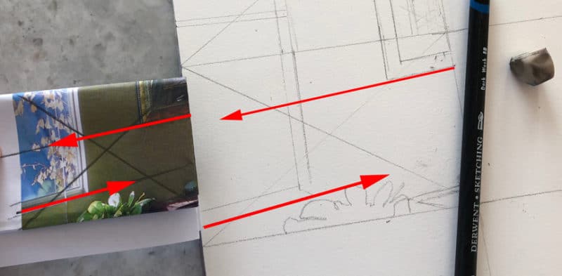 a section from a reference photo folded into a rectangle, and a rectangular square drawn on paper as a guide