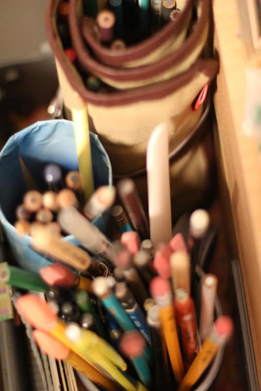 assorted pencils in an art studio, organized in containers
