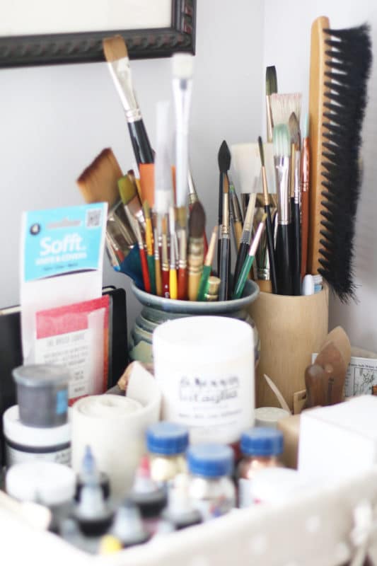 art studio brushes and ink stored in pretty ceramic containers