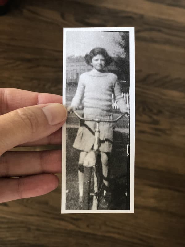 small black and white vintage photo of a girl on a bike from the mid 1940's